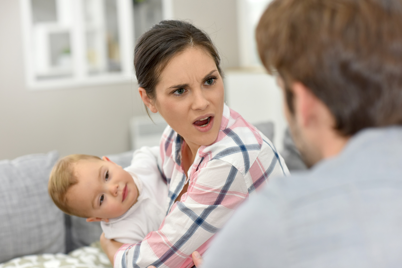 Man and woman arguing in front of baby