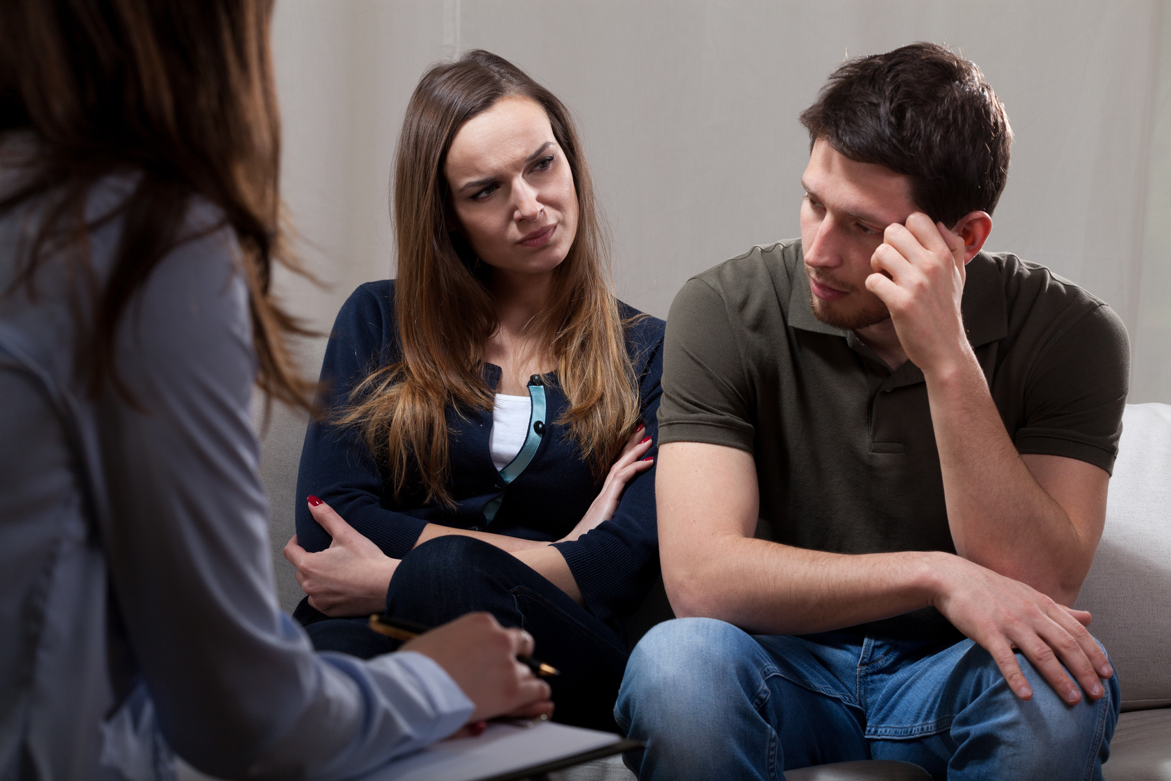 Unhappy at odds couple sitting on psychotherapy session