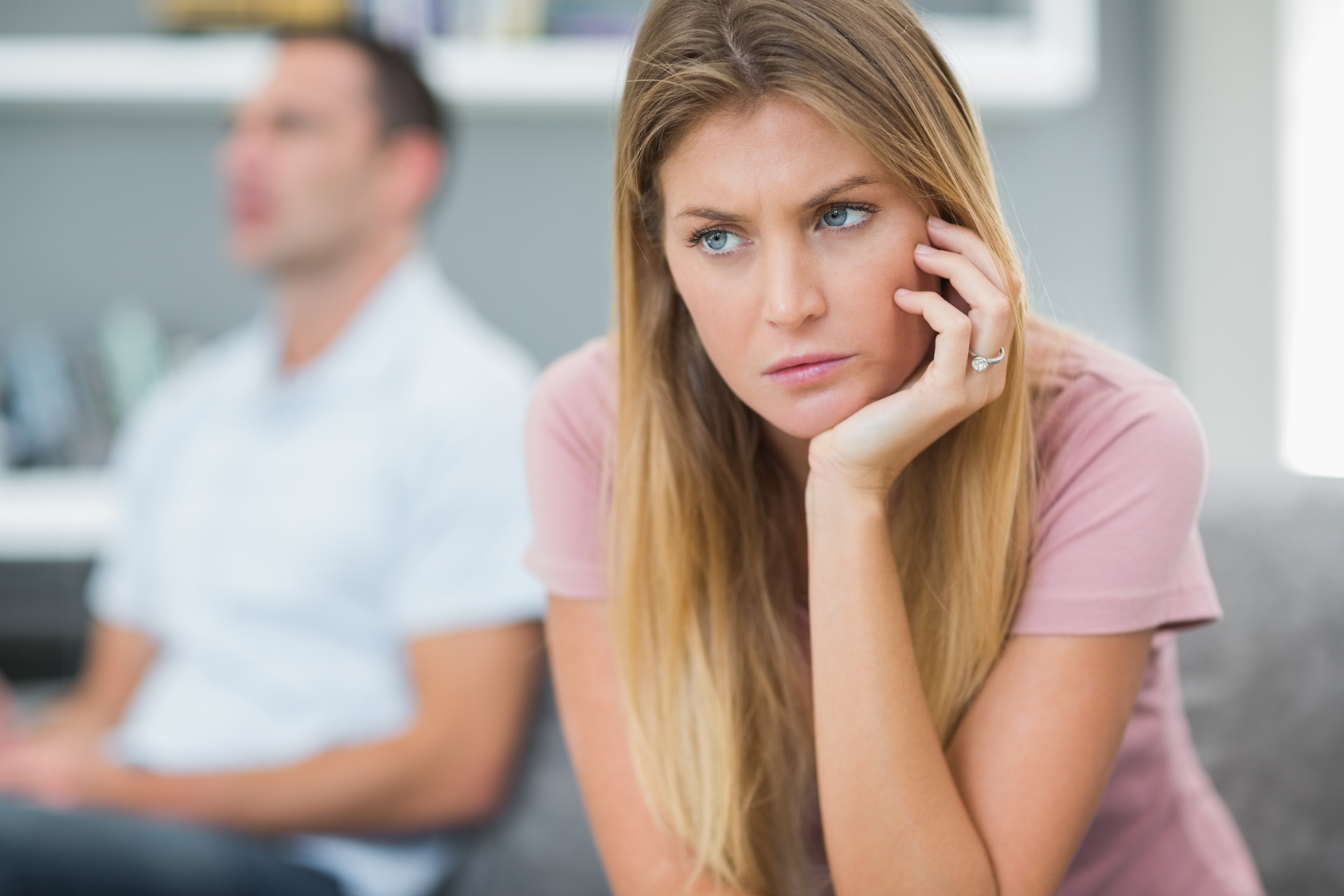 Sad woman thinking on couch after fight with husband in living room at home