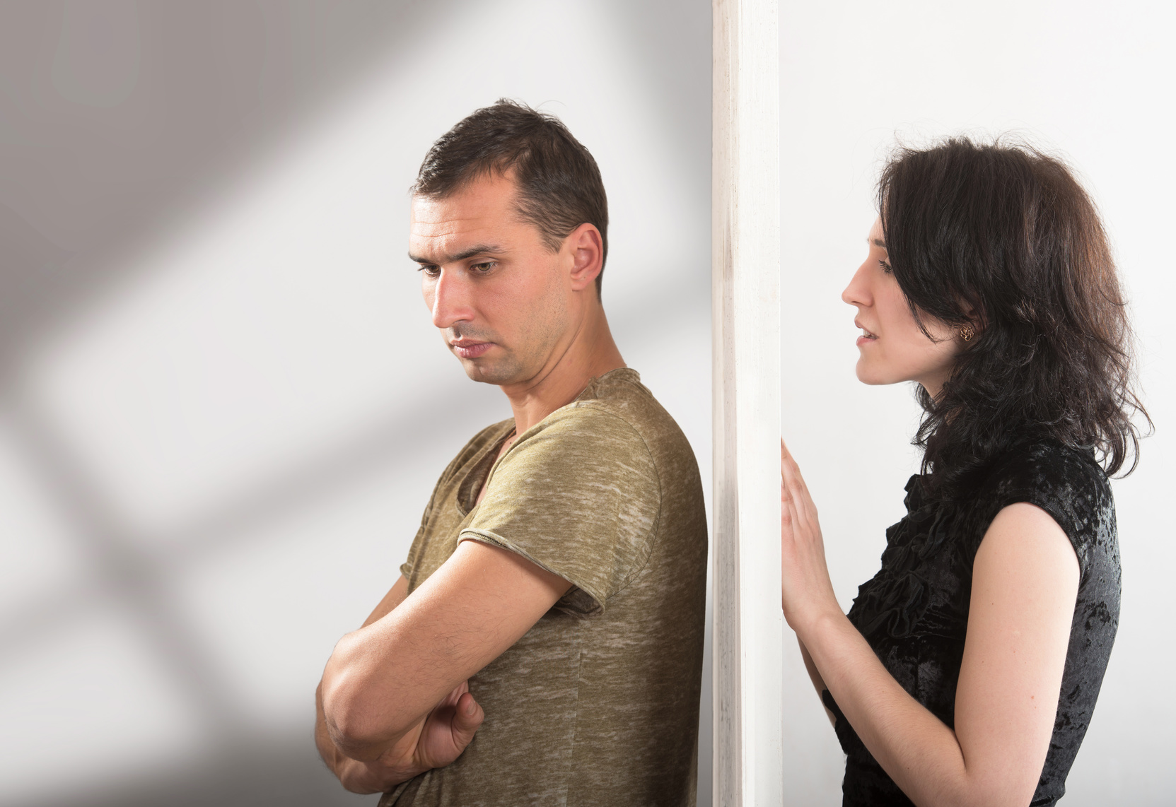 Conflict between man and woman standing on either side of a door